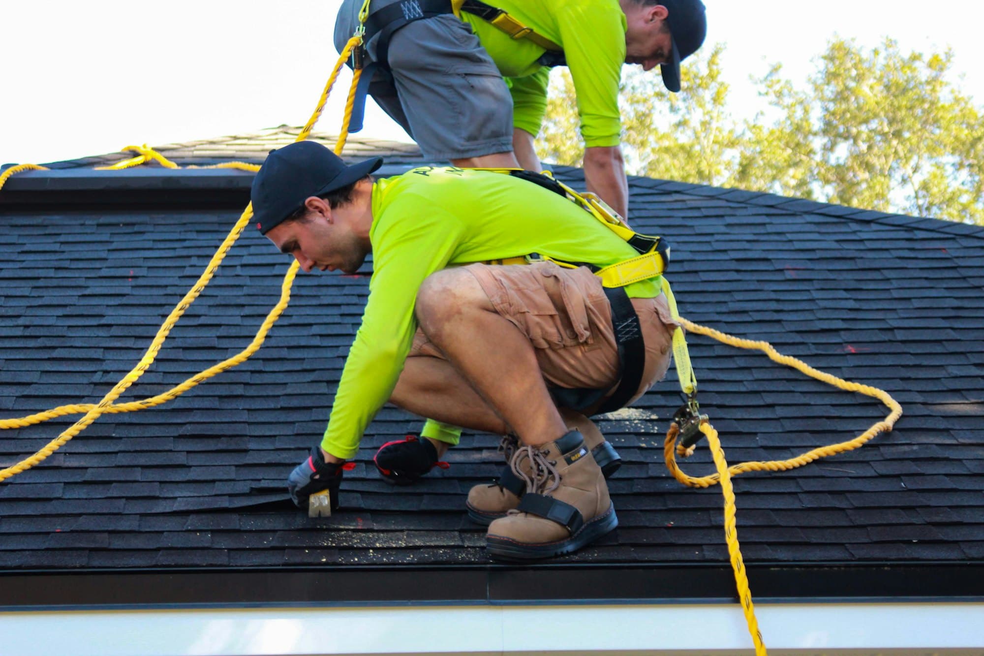 Roofers at work while Riley answers the phone